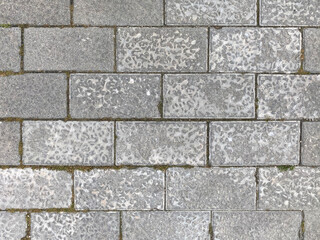 Textured background of an exterior floor with rows of gray concrete rectangular tiles