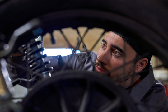 Focused mechanic working with motorcycle in garage