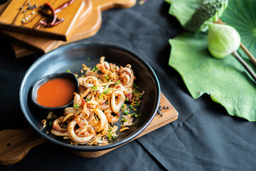 Fried squid with garlic pepper in the plate black - Asian food style