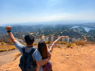 A couple celebrating after finishing a hike to the Hollywood signs in Los Angeles, California, USA.