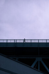 A woman running on a bridge.