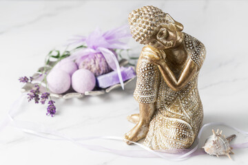 Sleeping  golden Buddha statuette and wellness set with lavender flowers