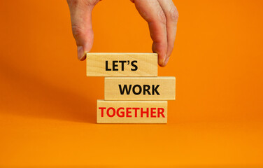 Work together symbol. Wooden blocks with words Let is work together on beautiful orange background....