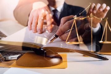 Business and lawyers discussing contract papers with brass scale on desk in office. Law, legal services, advice, justice and law concept picture with film grain effect