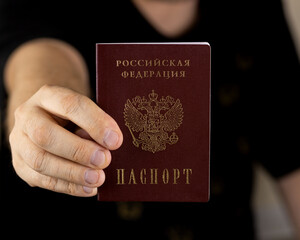 A human hand with a Russian passport in close-up. The concept of obtaining citizenship of the...