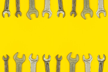 Various wrench tools border backround, yellow worker table workspace concept, top view and copy space photo