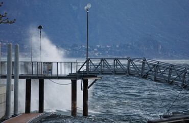 waves crashing on the pier on windy lake Maggiore, Ticino