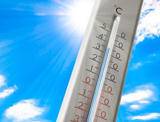 Weather thermometer with high temperature outdoors on hot sunny day. Heat stroke warning