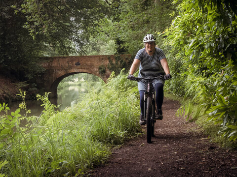 Woman cycling next to canal