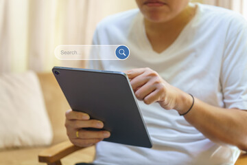 Technology Concept. Man hand holding and using computer tablet with search bar box icon.