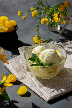 Lemon ice cream balls on the gray background with yellow flowers 