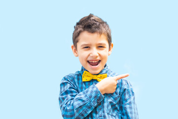 cheerful boy shows a finger gesture. Portrait of a boy on a blue background