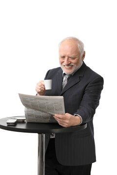 Happy senior businessman reading newspaper