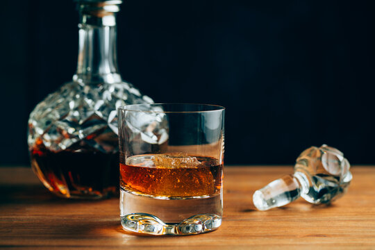 Glass of whiskey near decanter