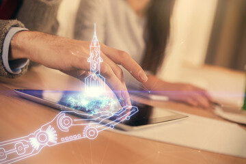 Double exposure of creative hologram drawing and man and woman working together holding and using a mobile device.