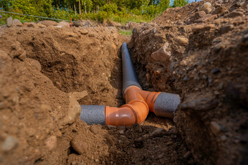 laying sewer pipes in the ground under the foundation. braiding several pipes into one