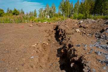 dug trench in the ground for laying sewer pipes under the foundation of the building