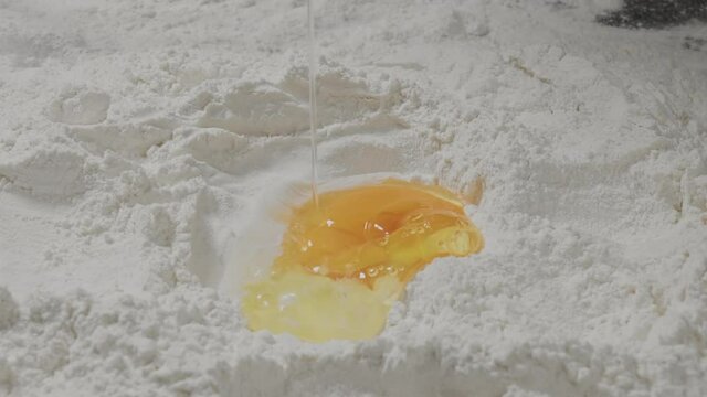 The broken egg fell into the flour. One egg in flour close up. The process of cooking.
