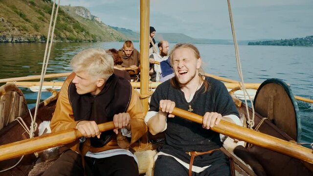 Viking Men Row Vigorously on Drrakar. The Vikings Sail on an Sld Ship
