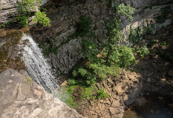 Fototapeta na wymiar Water flowing over the cliff edge at Ozone falls in Tennessee as the water flows into the pool below