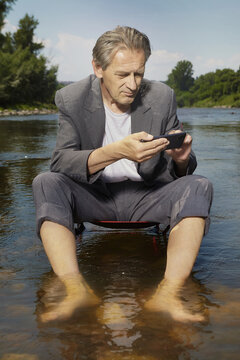 Manager in grey suit became crazy of hot weather and cooling in river