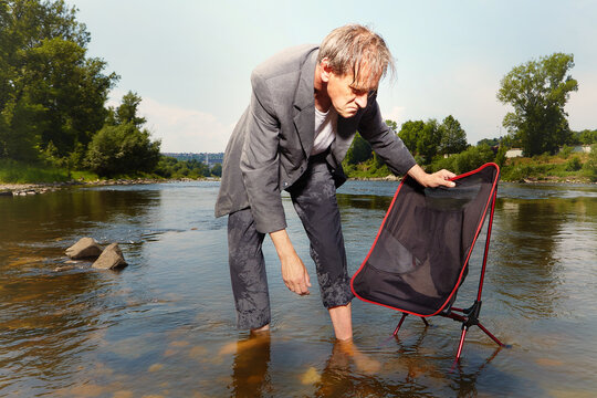 Manager in grey suit became crazy of hot weather and cooling in river
