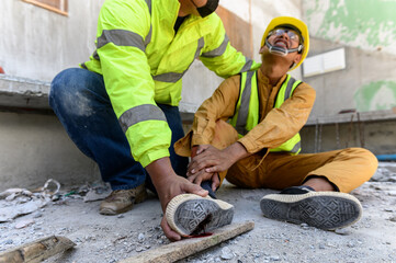 Builder worker has an accident at work. His feet stepped on nails embedded in wood old with foreman...