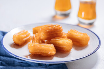 Bosnian and Turkish dessert called Tulumba served on a brught background with cup of tea