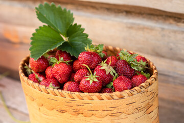 strawberries in a basket of birch on an old wooden background