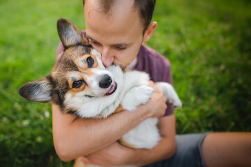 Sable welsh corgi pembroke and his owner, happy and relaxed during a walk in a park