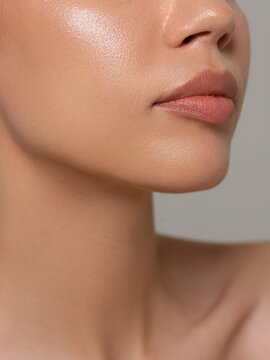 Sexual full lips. Natural gloss of lips and woman's skin. The mouth is closed. Increase in lips, cosmetology. Pink lips and long neck.