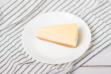 classic cheesecake on a white wooden table.