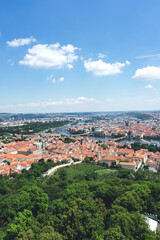 Fototapeta na wymiar Panorama of the beautiful old town in summer. Europe's old historic capital is surrounded by trees. Panorama of the cozy streets of the old Czech city on a background of blue sky.