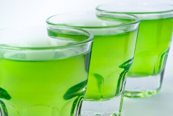 Sweet dessert, green fruit jelly in glass glasses on a white background close-up