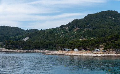 Fototapeta premium A view of the seaside campsite for motorhomes hidden in a dense forest