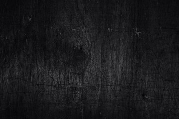 Black background. Old plywood texture with scratches and dents. Monochrome photo.