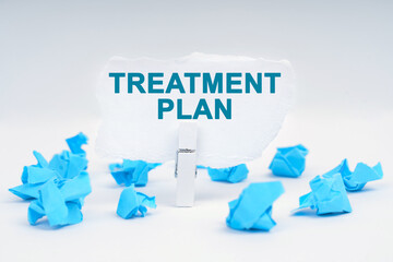 On the table are blue pieces of paper and paper with the inscription - TREATMENT PLAN