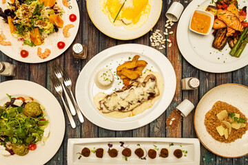 typical dishes and salads of Spanish gastronomy, oxtail croquettes, honeyed rice, pepper sirloin, grilled salmon with vegetables, salad with walnuts, oranges and prawns