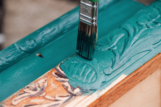 brush with blue or green paint macro painting old wooden furniture for reuse, eco-friendly lifestyle. 