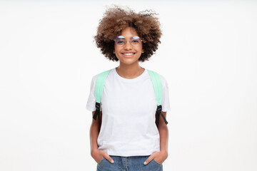 Portrait of smiling african school girl wearing white t-shirt, glasses and backpack, isolated on...