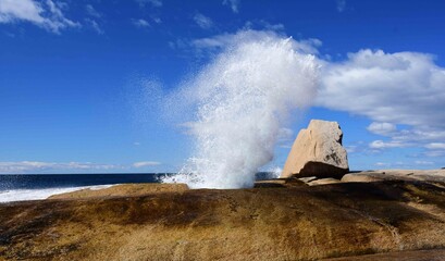 bicheno   blowhole spouting next to the sea on a sunny day  in  bicheno, tasmania, australia   