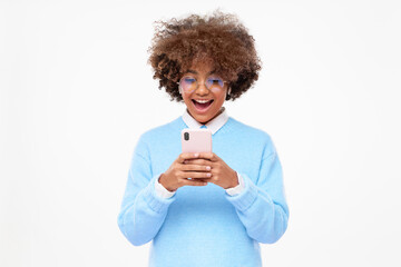 Portrait of shocked but happy african girl with wow face, holding phone in hands, surprised with commercial offer, isolated on gray background