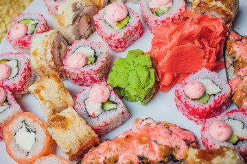 Beautifully decorated sushi on a plate and chopsticks are near it. Sushi is the traditional Asian...