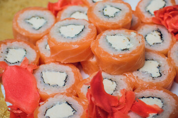 Beautifully decorated sushi on a plate and chopsticks are near it. Sushi is the traditional Asian...