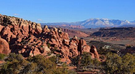 panoramic view of eroded hoodoos and distant mountains at fiery furnace,  in arches national park, utah