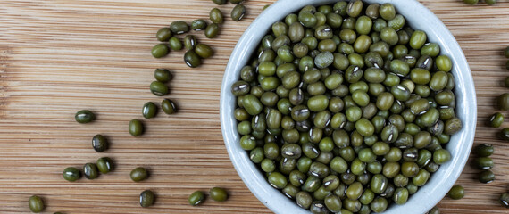 Green bean or mung bean or moyashi bean on wooden table background. Size for banner.