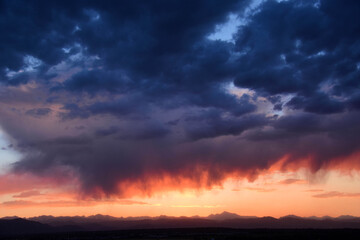 Fototapeta na wymiar dramatic virga clouds at sunset over the front range of the colorado rocky mountains, as seen from broomfield, colorado 