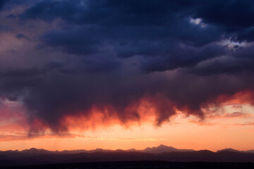 Fototapeta na wymiar dramatic virga clouds at sunset over the front range of the colorado rocky mountains, as seen from broomfield, colorado 