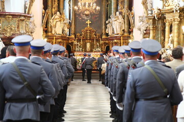 Polska policja w galowych mundurach na uroczystości w kościele. 
