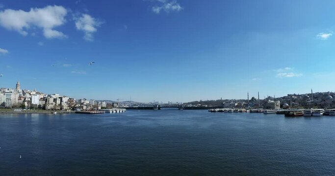 ISTANBUL - FEBRUARY 21, 2021: Panoramic view from Golden Horn Metro Bridge on Istanbul, Turkey. Wide shot, pan.